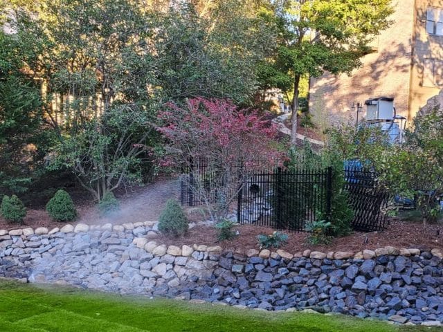 Transform Your Yard with a Stunning Fieldstone Retaining Wall, Custom Patio, and River Rock Dry Creek Bed